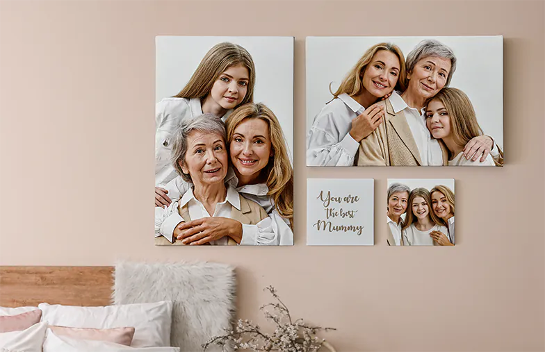 Foto Canvas Display Panelen van Printerpix|Canvas Display Panelen|Man en vrouw die een fotocanvas ophangen met een vakantiefoto|Vrouw die drie zwart-wit familiefotocanvassen ophangt|Moeder en vier jonge kinderen zitten op de bank voor vier fotocanvassen|Koppel voor een blauwe muur met negen vierkante fotocanvassen|||||